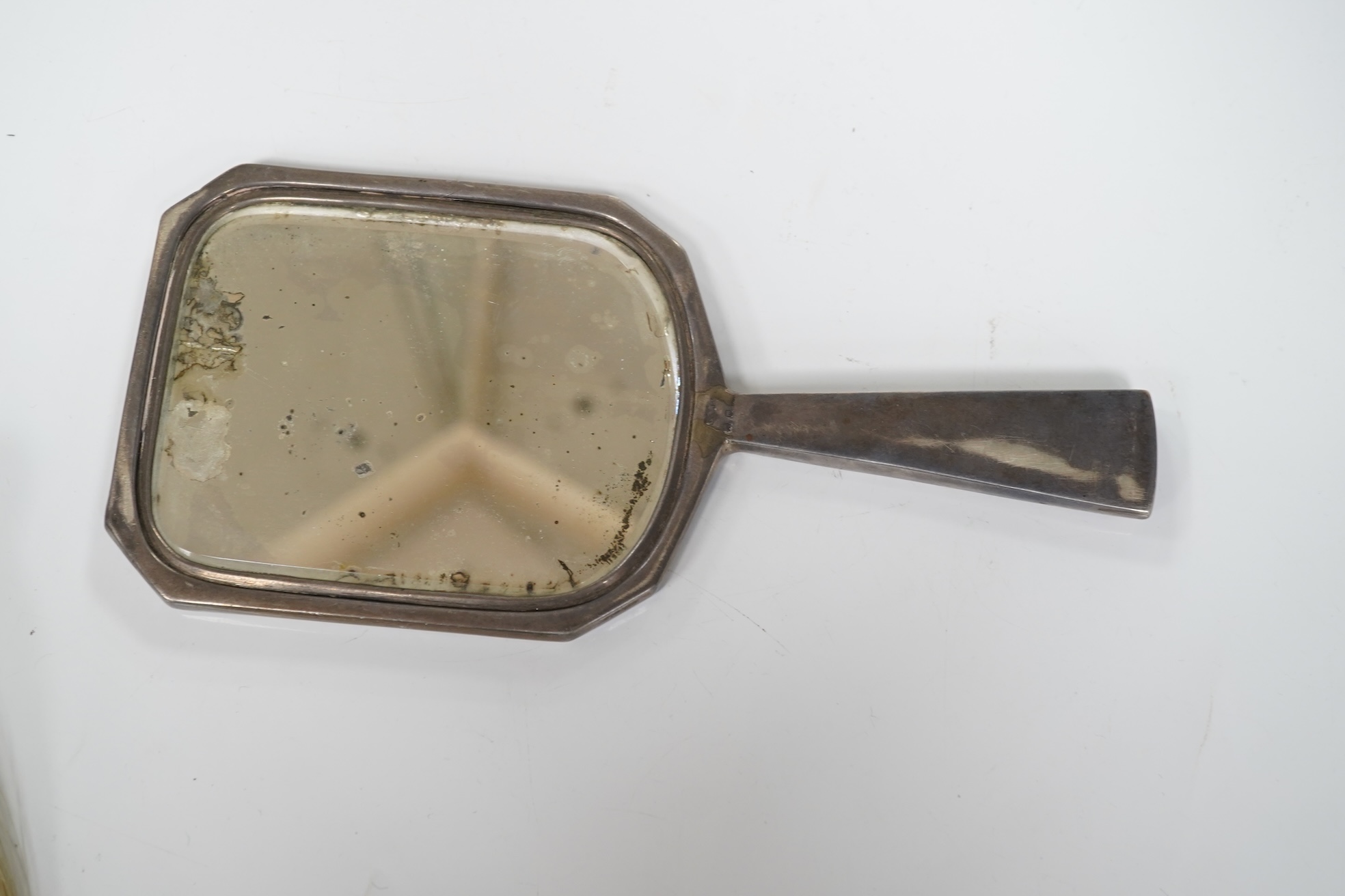 An Art Deco silver mounted hand mirror by Collett & Anderson, London, circa 1930, 22.7cm, together with a silver mounted crumb brush, clothes brush and an engine turned silver compact.